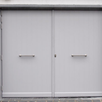 Pastorie poort met vertikale infrezingen en siertrekkers aan de buitenzijde